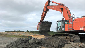 The excavator attachment crushes mined clay down to 4-in. minus while simultaneously loading haul trucks. Photo courtesy of ALLU.