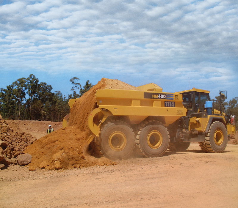 As the name implies, rear-eject bodies use an ejector blade to discharge material. Without moving or raising the truck bed, the blade pushes material toward the rear of the truck. This simplifies the dumping process and enhances efficiency because operators don’t have to wait for the bed to lower before driving away. Photo: Philippi-Hagenbuch