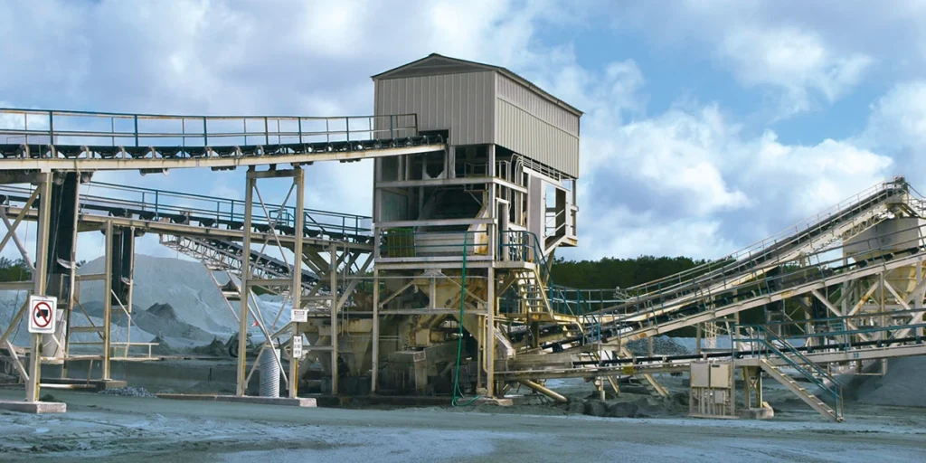 A covered vibrating screen tower provides multiple decks of screening capacity in a stationary plant setup. (Photo: P&Q Staff)