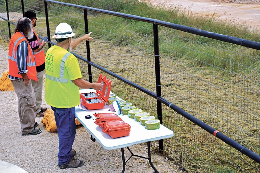Photo of blasting personnel overseeing initiation controls and safety procedures from a secure location.