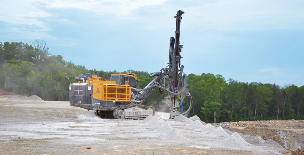 Photo of equipment drilling blastholes in a pattern to optimize fragmentation and safety.