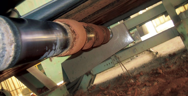 Sticky carryback can cake onto a roller, rendering it ineffective and costly to service or replace. (Photo: Martin Engineering)